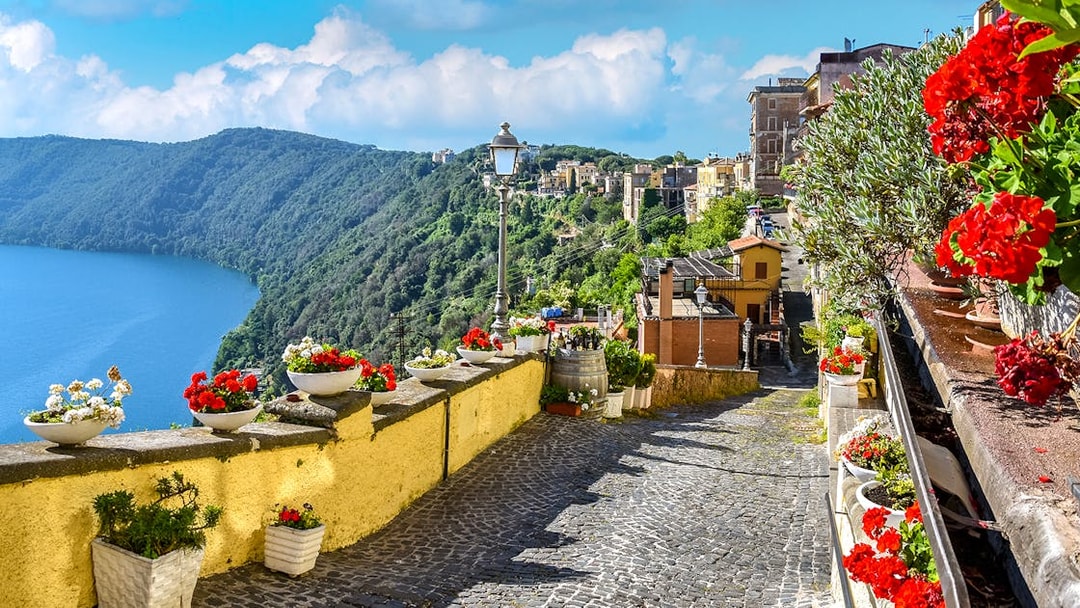 Cobblestone path with flowers overlooking Lake Albano near Castel Gandolfo, Italy.
