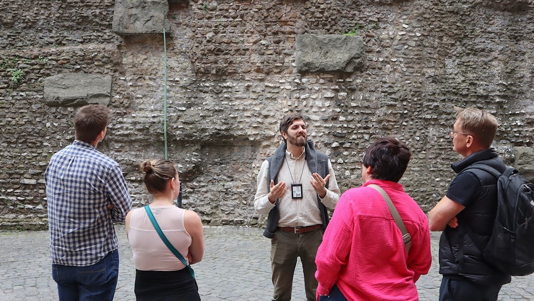 Guide explaining history to tourists at Castel Sant'Angelo, Rome.