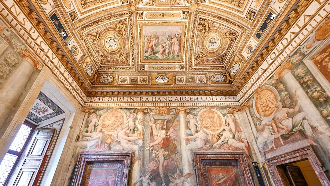 Interior of Castel Sant'Angelo with ornate ceiling and detailed frescoes in Rome, Italy.