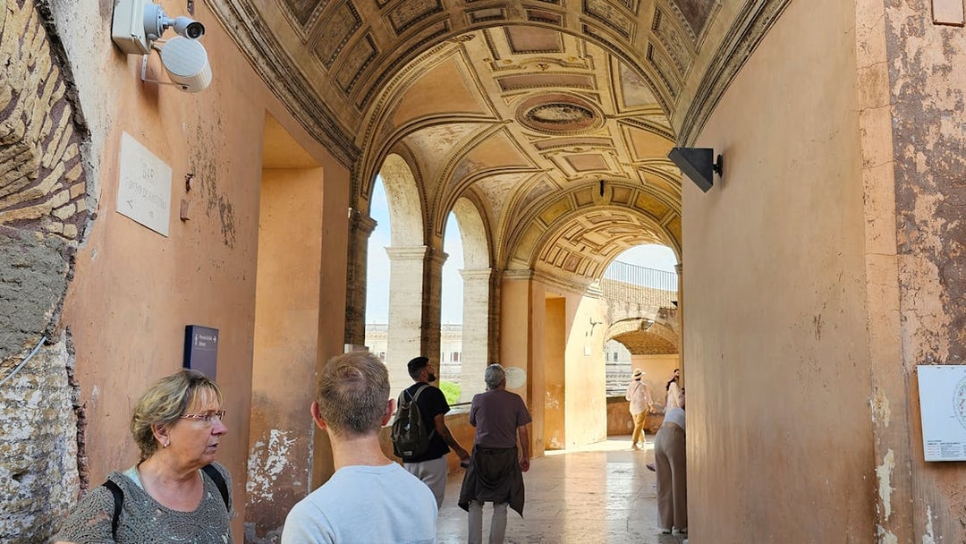 Visitors exploring the arched corridor of Castel Sant'Angelo in Rome.