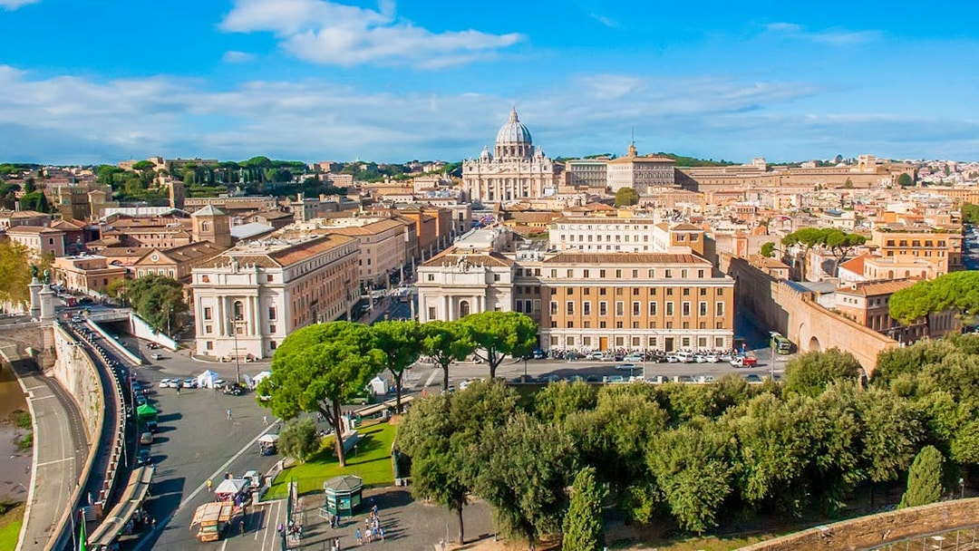 View of Vatican City from Passetto di Borgo, featuring St. Peter's Basilica and surrounding architecture.