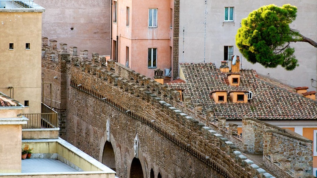 Passetto di Borgo stone wall with arches and adjacent buildings in Rome.