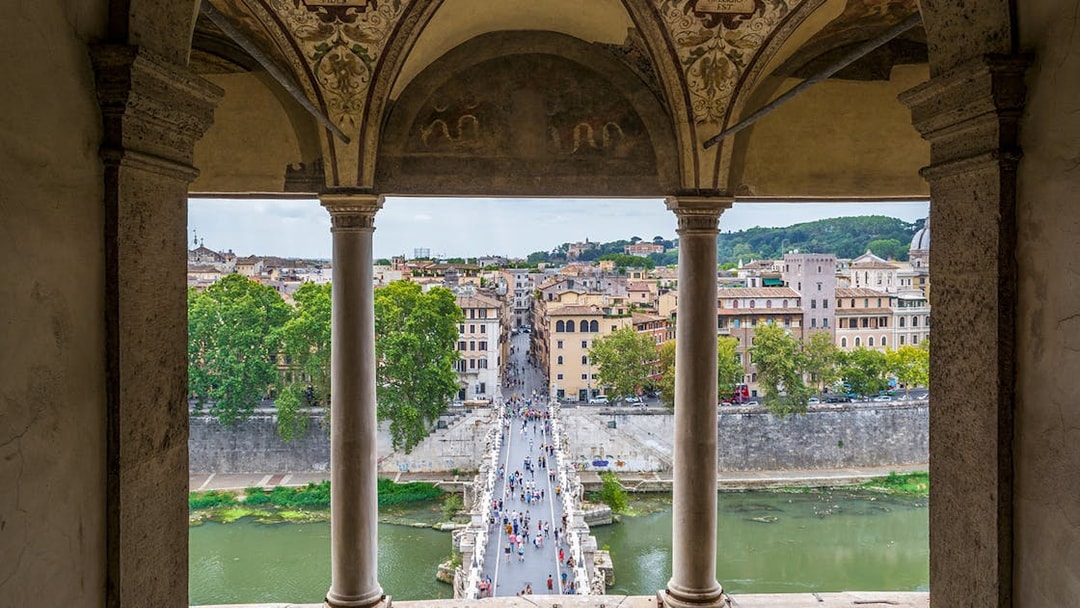 View from Castel Sant'Angelo of people walking on St. Angel Bridge, Rome.