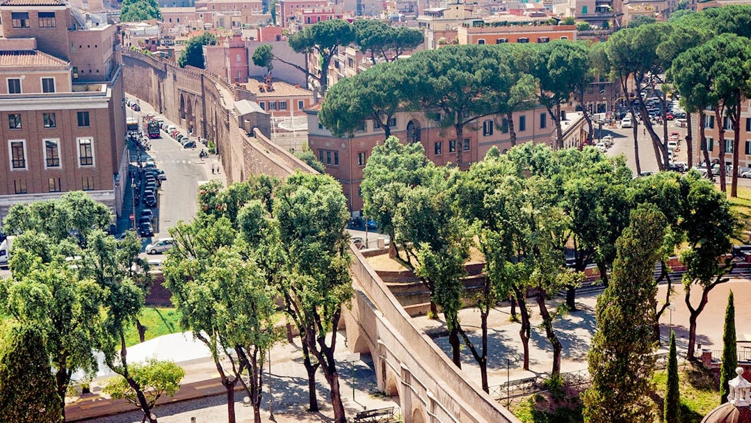 Passetto di Borgo connecting to Vatican City, surrounded by trees and historic buildings.