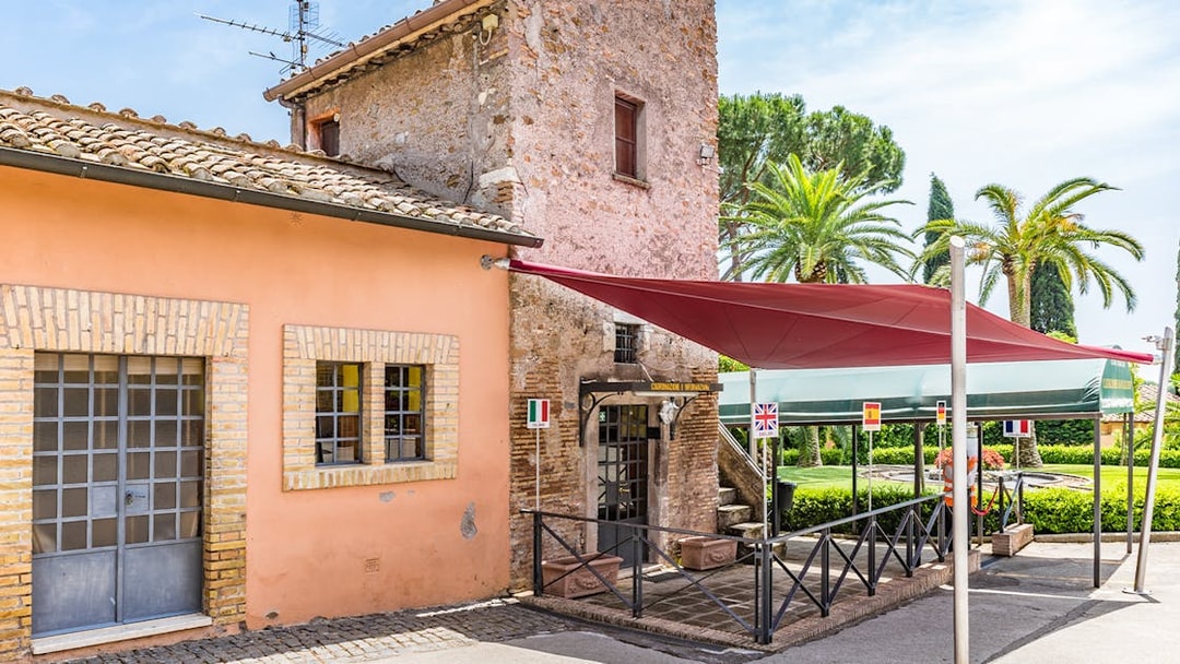 Entrance to the Catacomb of Callixtus on the Appian Way, Italy, with flags and canopy.