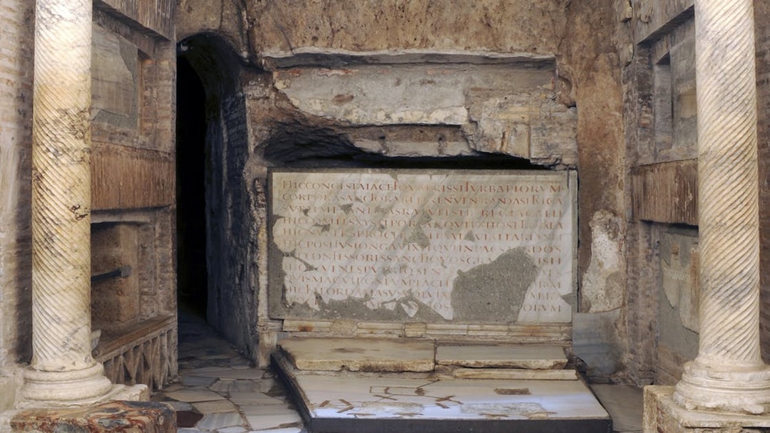 Ancient stone inscriptions and columns in the Catacombs of St Callixtus, Rome.
