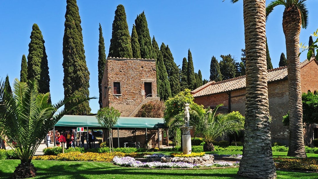 Entrance to Catacombs of St Callixtus with garden and stone building in Rome.