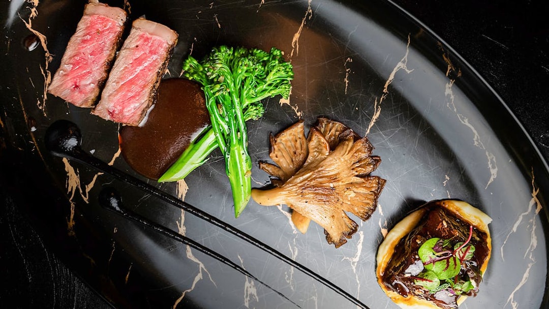 Lunch set menu with steak, broccolini, mushrooms, and sauce at CÉ LA VI Dubai.