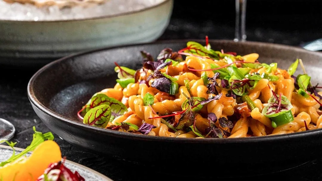 Pasta dish with greens served at CÉ LA VI Dubai with Burj Khalifa views.