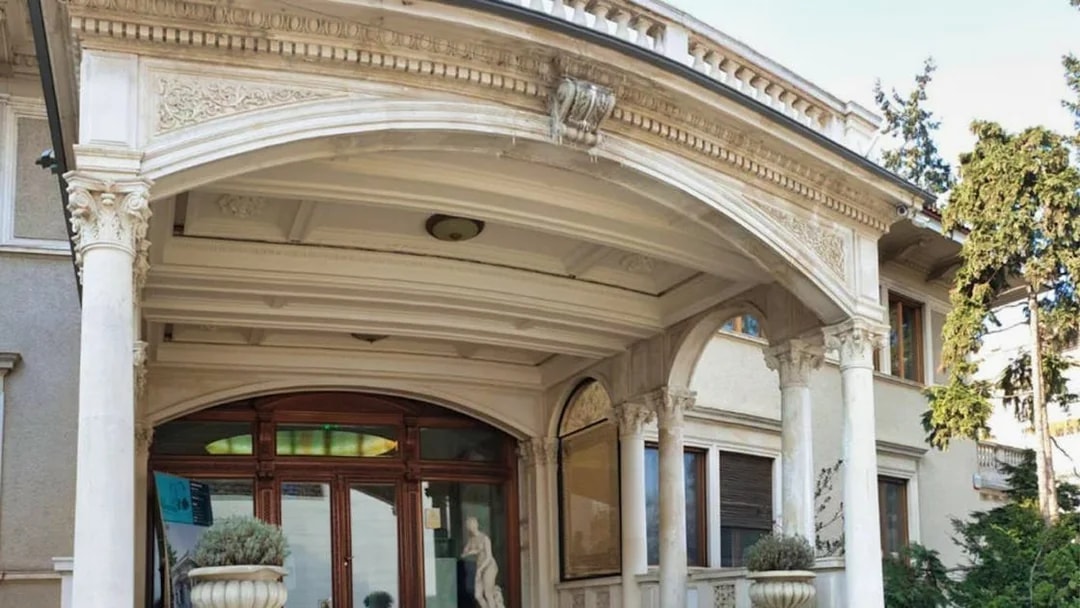 Entrance of Ceausescu Mansion with ornate columns and archway, Bucharest.