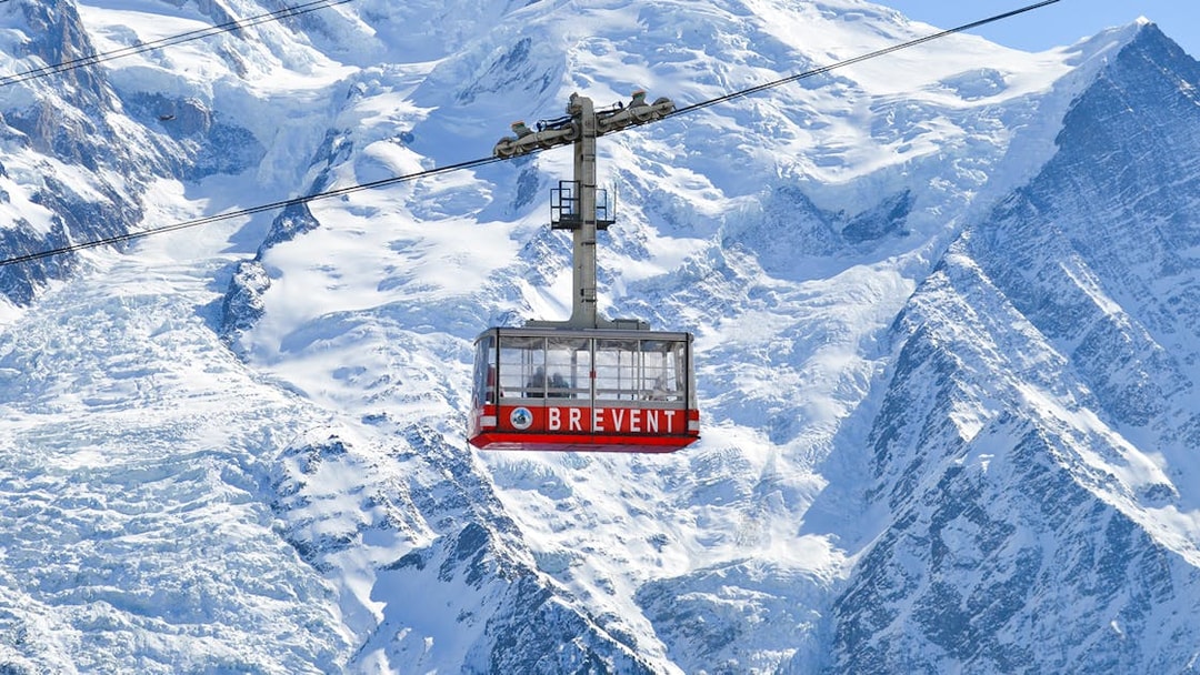 Cable car ascending Mont Blanc with snowy peaks in Chamonix, France.