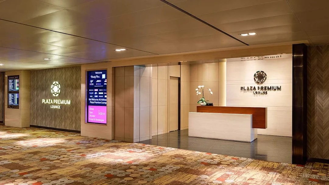 Plaza Premium Lounge entrance at T1 International Departures with reception desk and signage.
