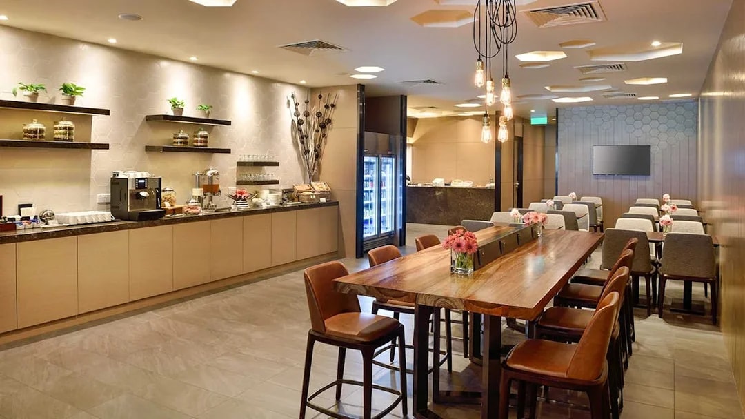 Plaza Premium Lounge T1 International Departures seating area with buffet and modern decor.