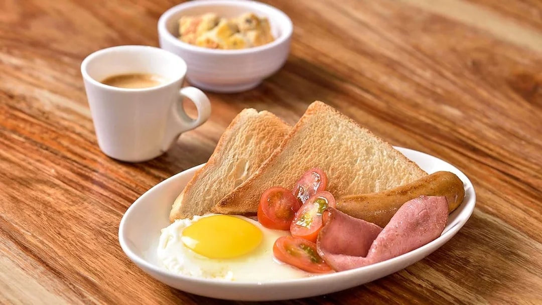 Breakfast plate with toast, egg, sausage, ham, and tomatoes at Plaza Premium Lounge, T1 International Departures.