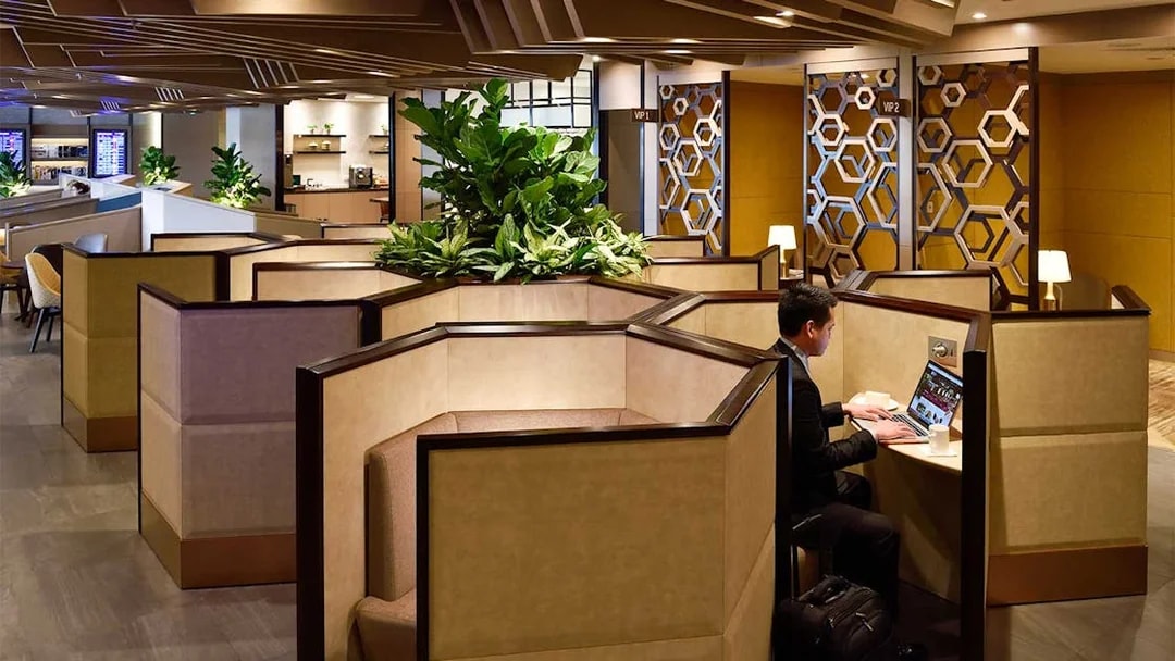 Plaza Premium Lounge T1 seating area with traveler using laptop, International Departures.