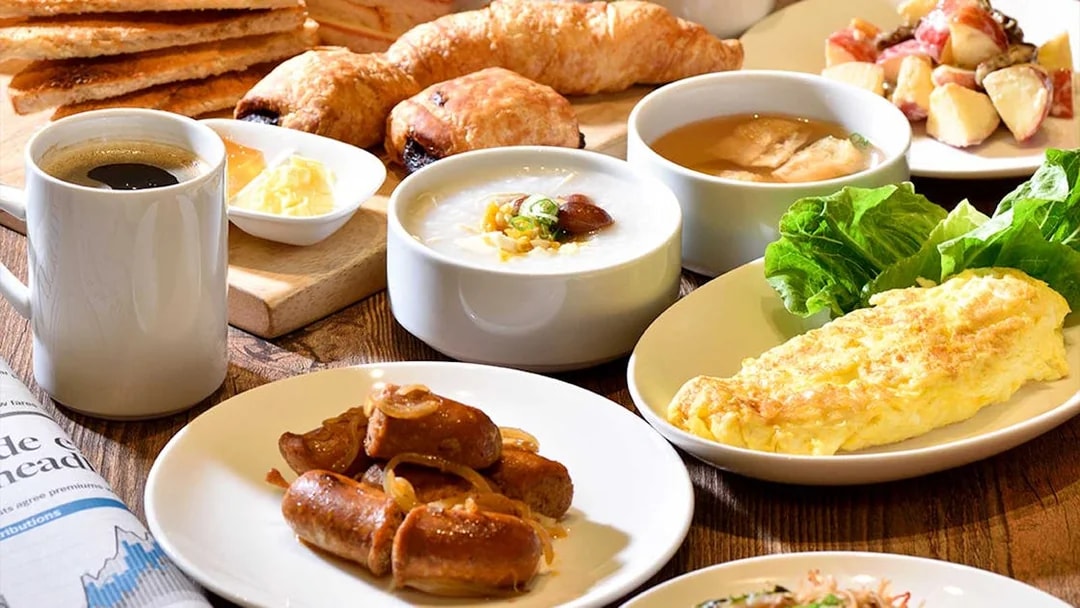 Breakfast spread with coffee, sausages, omelette, pastries, and fruit at Plaza Premium Lounge, T1 International Departures.