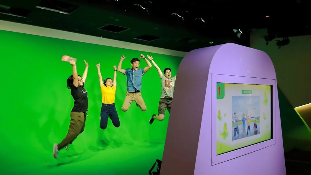 Visitors jumping in front of a green screen at Changi Experience Studio interactive exhibit.