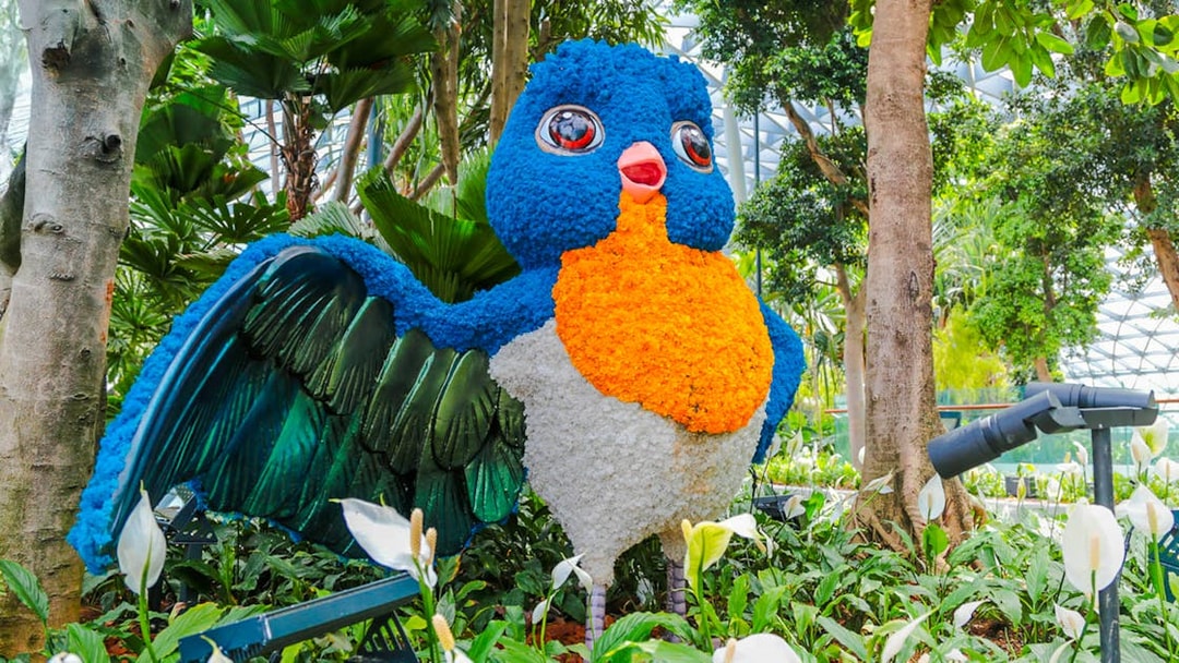Topiary bird sculpture in Canopy Park, Jewel Changi, surrounded by lush greenery.