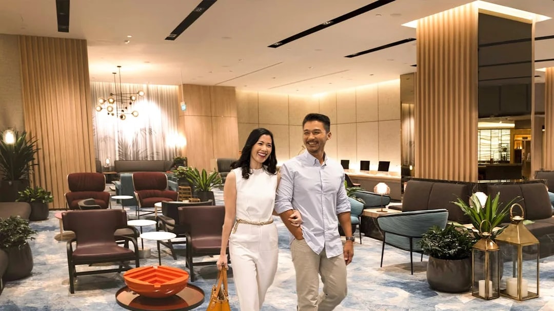 Couple walking in Changi Lounge, Singapore, surrounded by modern seating and decor.