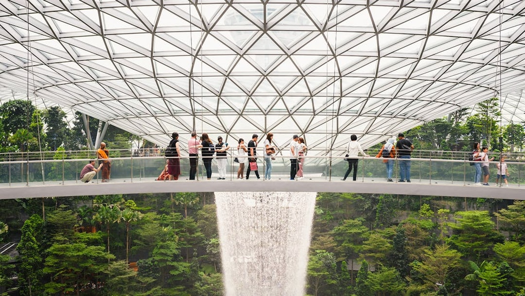 Visitors on a bridge overlooking the indoor waterfall at Jewel Changi Airport, Singapore.