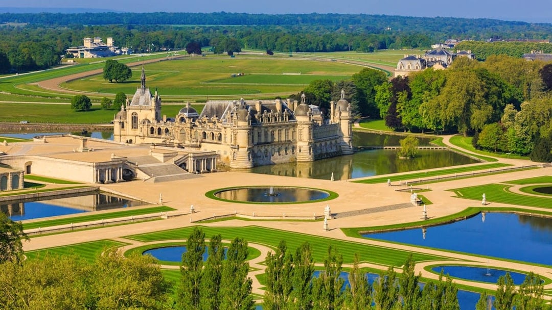 Chateau of Chantilly with gardens and reflecting pools, France.