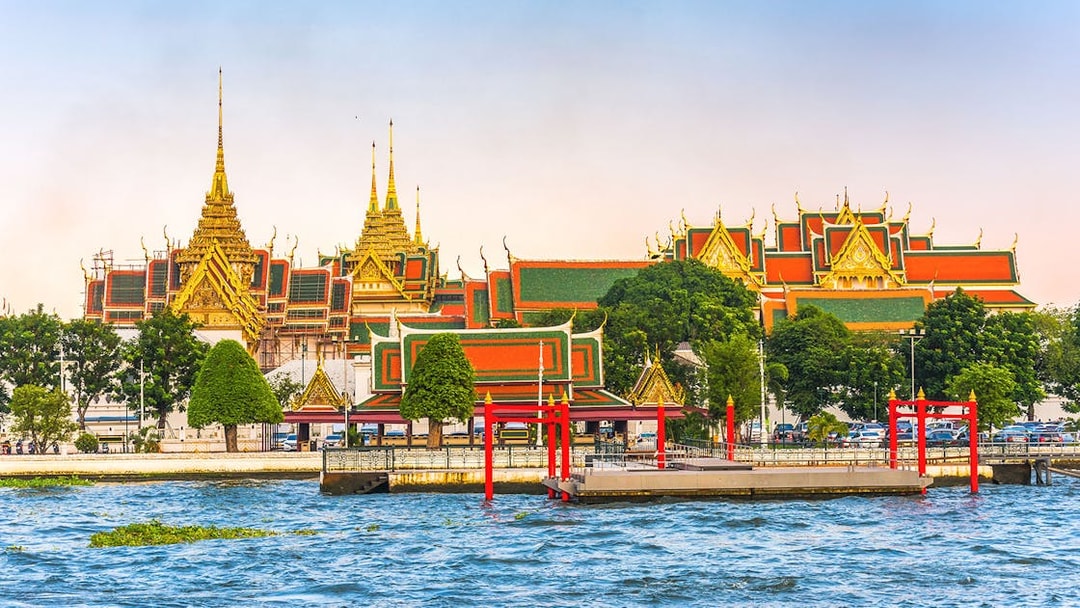 Grand Palace view from Chao Phraya River, Bangkok, with hop-on-hop-off boat dock.