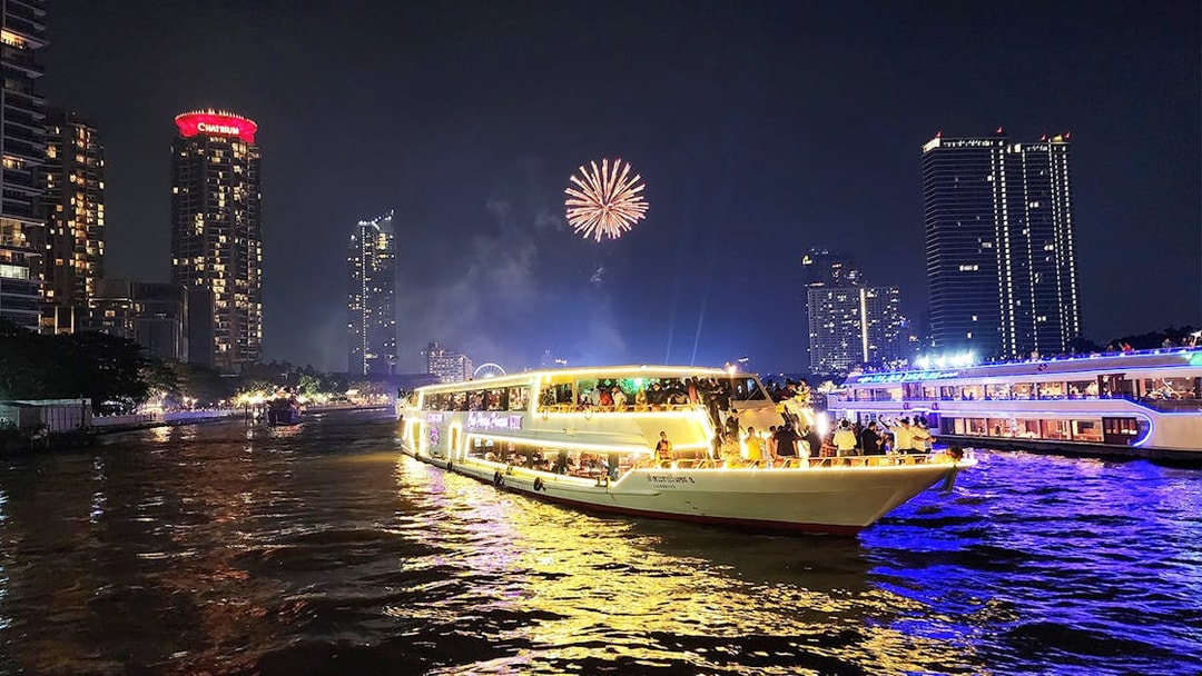 Chao Phraya Princess Cruise with fireworks over Bangkok skyline at night.