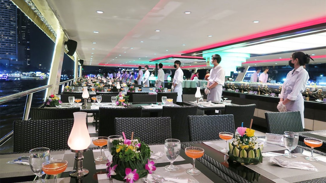 Dining setup on Chao Phraya Princess Cruise, Bangkok, with tables and staff.