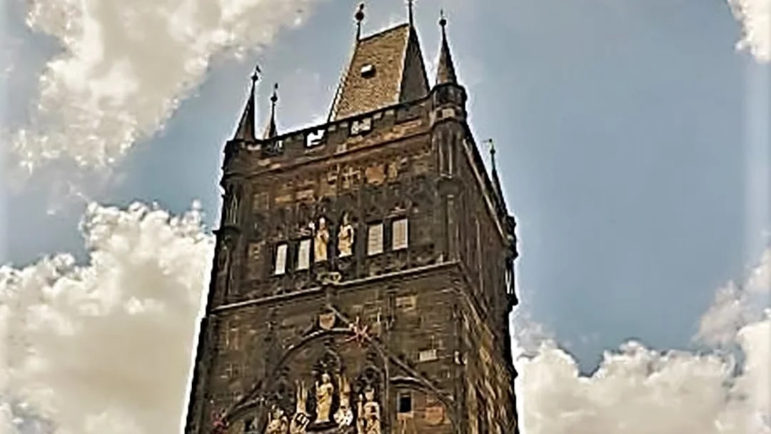 Charles Bridge Tower against a cloudy sky in Prague.