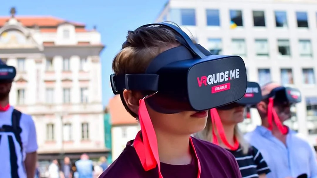Visitors using VR headsets on a mobile-guided tour of Charles Bridge, Prague.