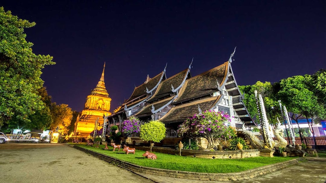 Chiang Mai temple illuminated at night during a bike tour.