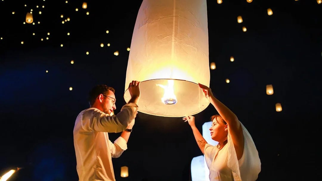 Releasing a sky lantern at Chiang Mai Sky Lanterns Festival, Thailand.
