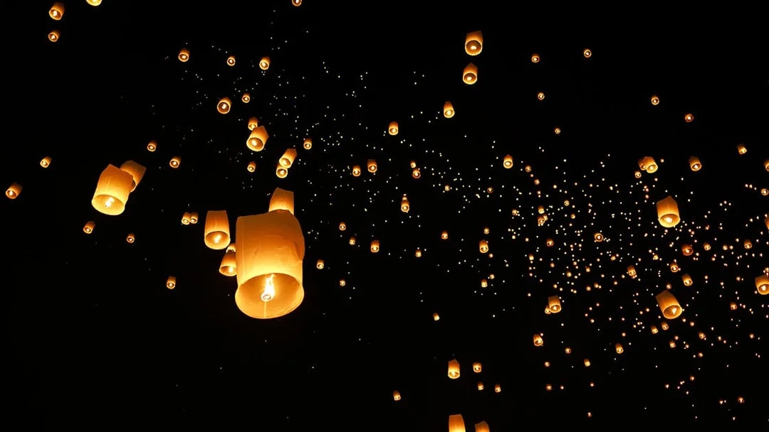 Lanterns floating in the night sky at Chiang Mai Sky Lanterns Festival 2025, Thailand.