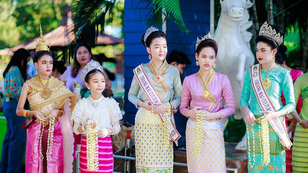 Young women and girls in traditional Thai attire and crowns at Chiang Mai Sky Lanterns Festival.