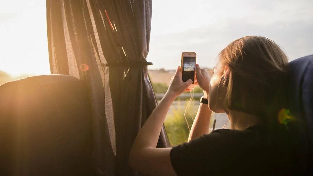Tourist taking photo from bus window on early morning trip to Chichen Itza.