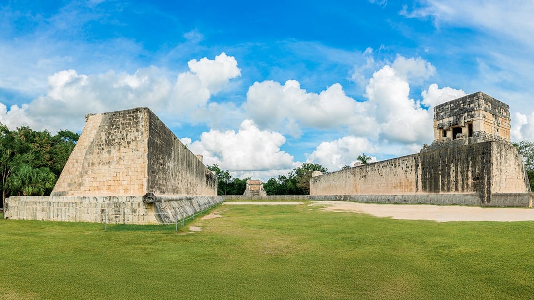 Mayan Ball Game Field at Chichen Itza with ancient stone walls and grassy court.