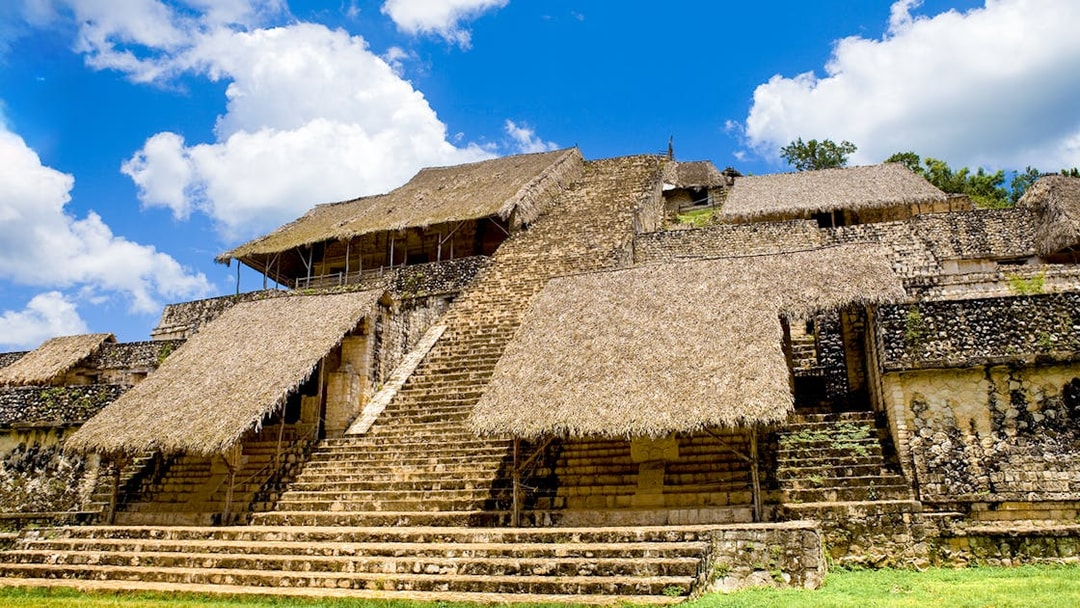 Ancient Mayan pyramid with thatched roofs at Ek Balam, Mexico.