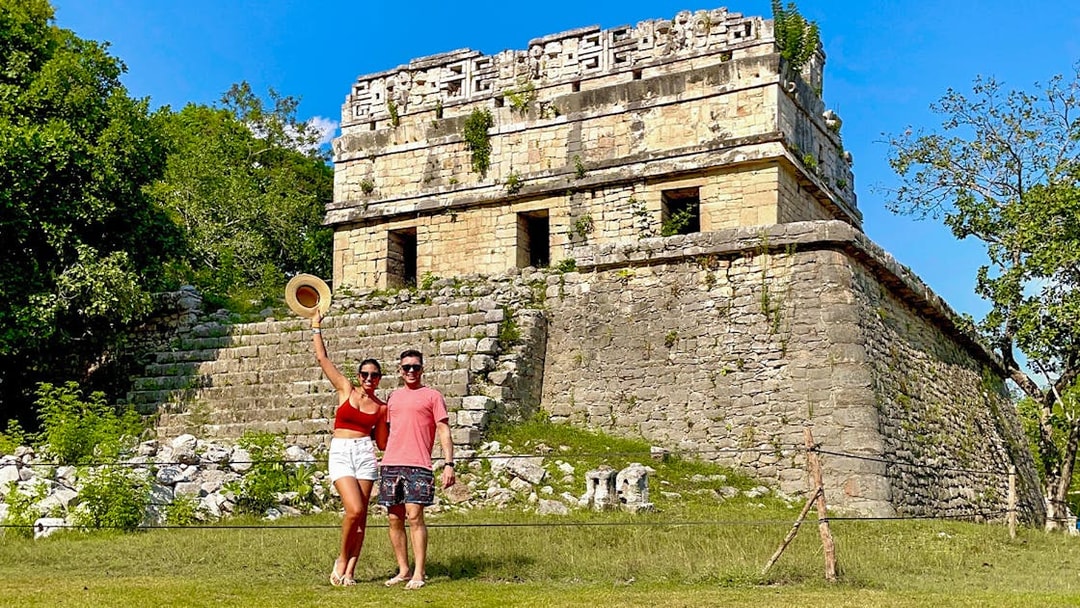 Couple posing in front of Chichen Itza temple, Mexico.