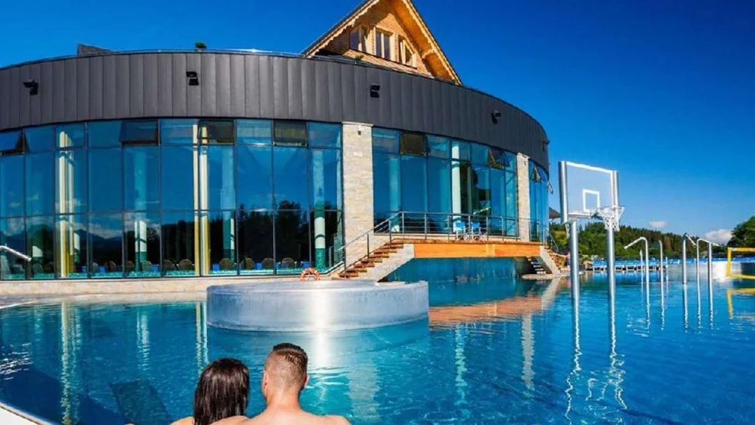 Couple relaxing in outdoor pool at Chocholow Thermal Baths Saunarium, Poland.