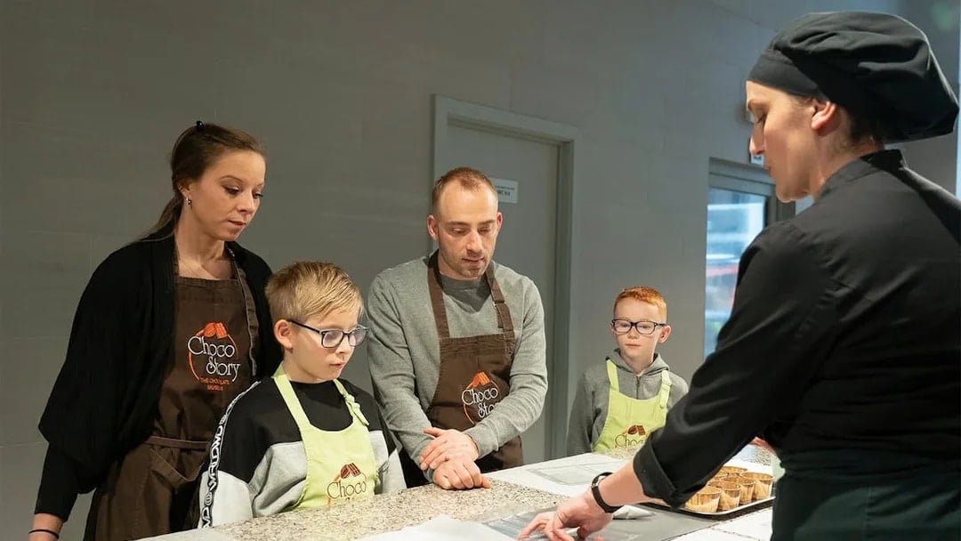 Family learning chocolate making at workshop in Brussels.