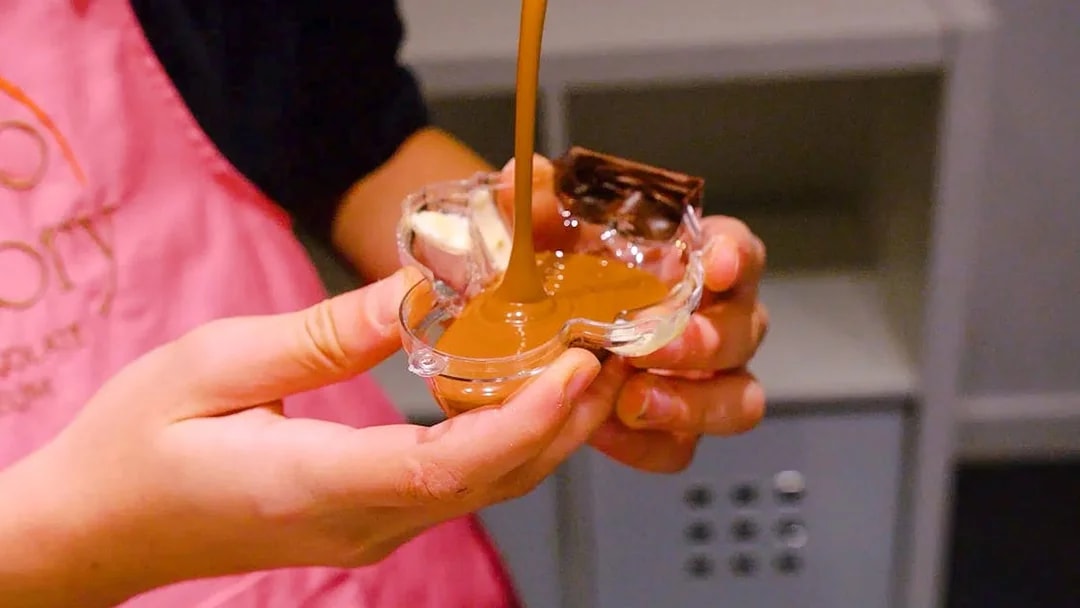 Pouring chocolate into a mold at Choco-Story Paris.