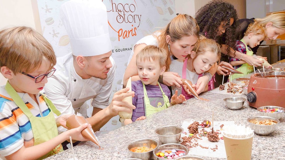 Children making chocolate treats with a chef at Choco-Story Paris.