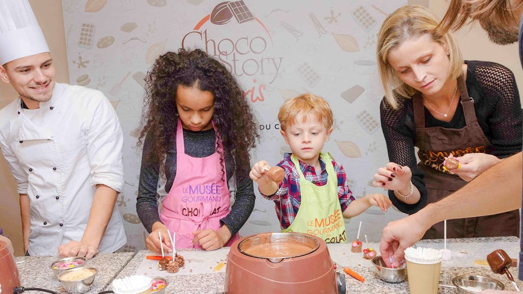 Chocolate chef guiding kids in chocolate-making at Choco-Story Paris.