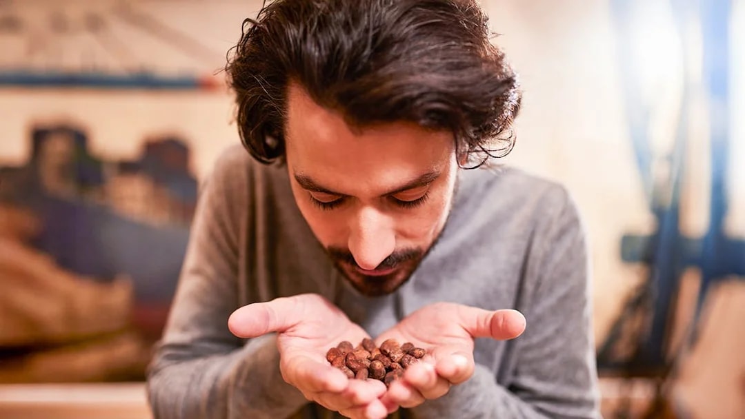 Guest smelling cocoa beans at Chocoversum, Hamburg.