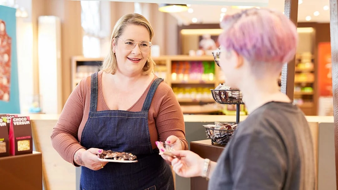 Chocolate tasting experience at Chocoversum, Hamburg with a guide offering samples.
