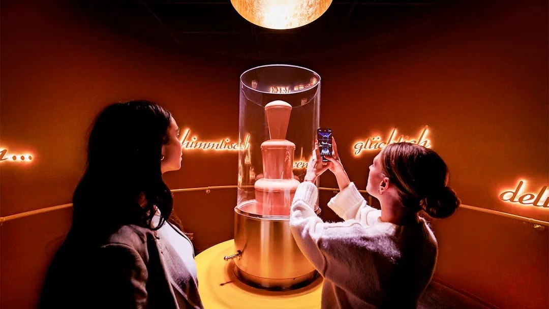 Tourists photographing chocolate fountain at Chocoversum, Hamburg.