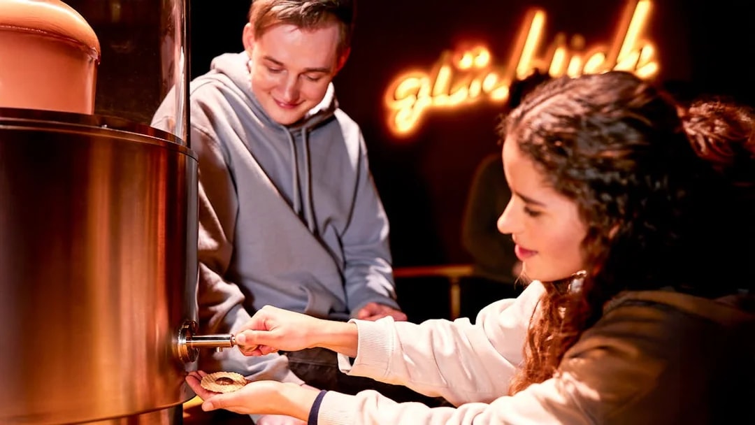 Woman adding chocolate fudge to a treat at Chocoversum, Hamburg.
