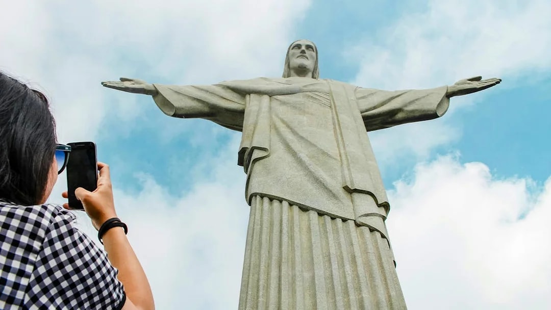 Person photographing Christ the Redeemer statue in Rio de Janeiro.
