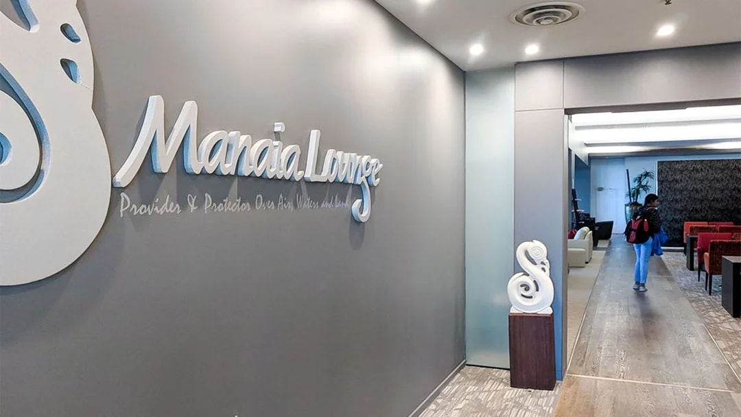 Plaza Premium Lounge entrance with seating area and decorative wall sign.