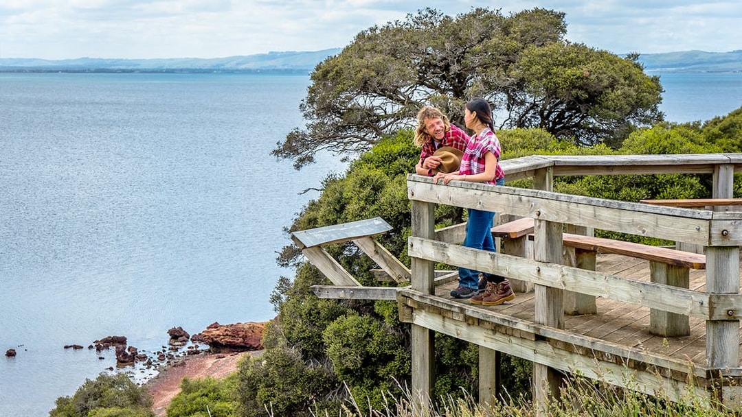 Visitors enjoying a scenic view from a wooden lookout on Churchill Island trail.